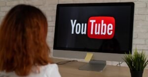 Person with red hair watching YouTube on a computer.